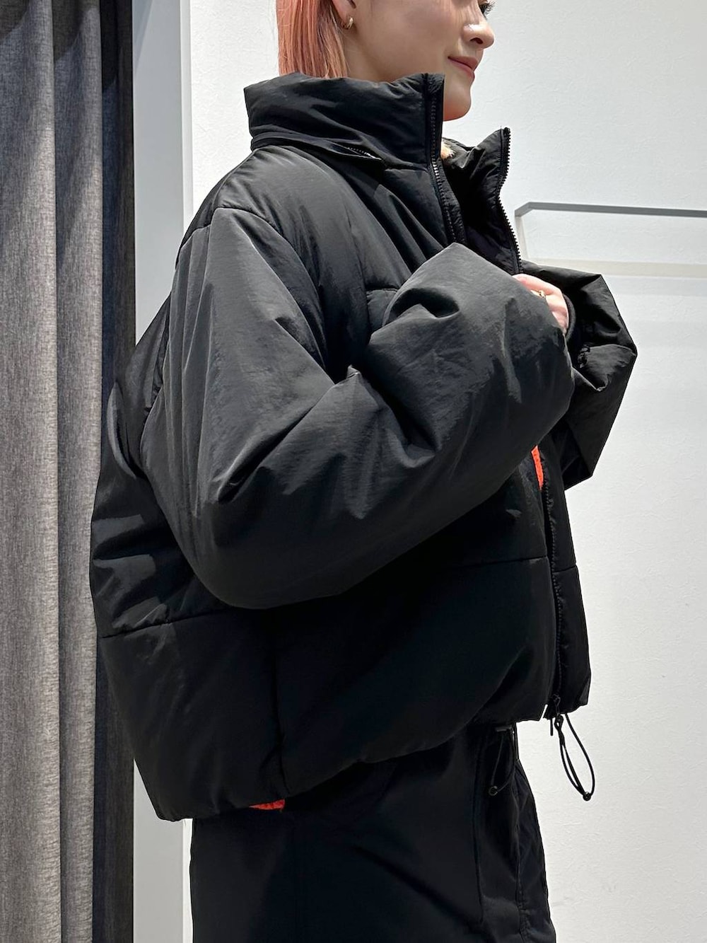 ブラック系のスカート、レッド系のニット/セーター、ブラック系のその他アウターを着用したレディースの秋コーディネートの5枚目の写真