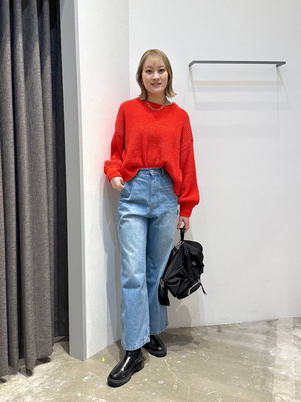 ブルー系のデニムパンツ、レッド系のニット/セーター、ブラック系のバックパック/リュックを着用したレディースの冬コーディネートの4枚目の写真