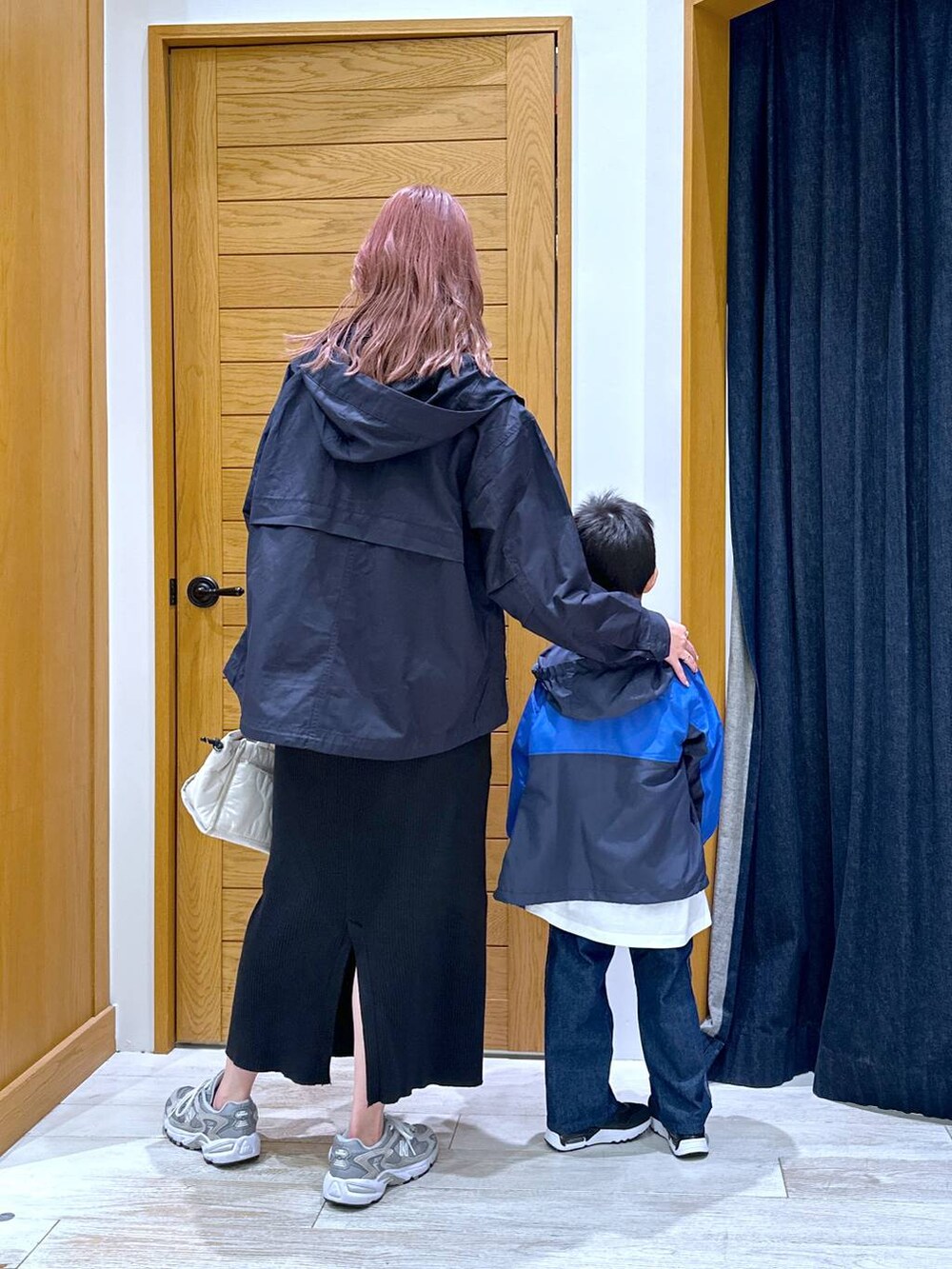 ブラック系のスカート、ブルー系のマウンテンパーカー、ホワイト系のショルダーバッグを着用したキッズの秋コーディネートの3枚目の写真