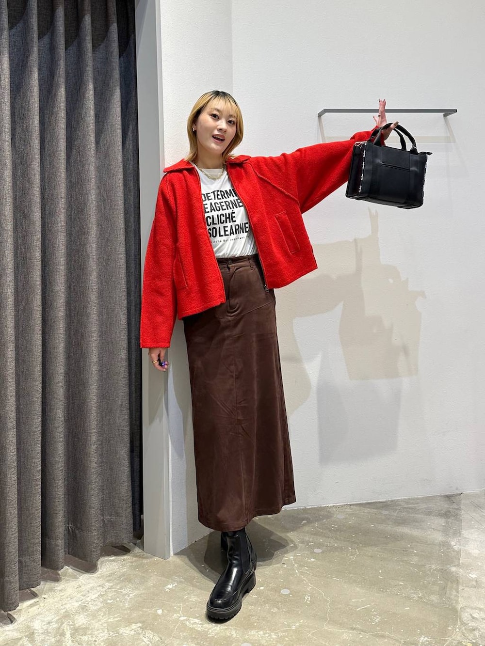 ホワイト系のTシャツ/カットソー、ブラウン系のスカート、ブラック系のトートバッグを着用したレディースの秋コーディネートの9枚目の写真