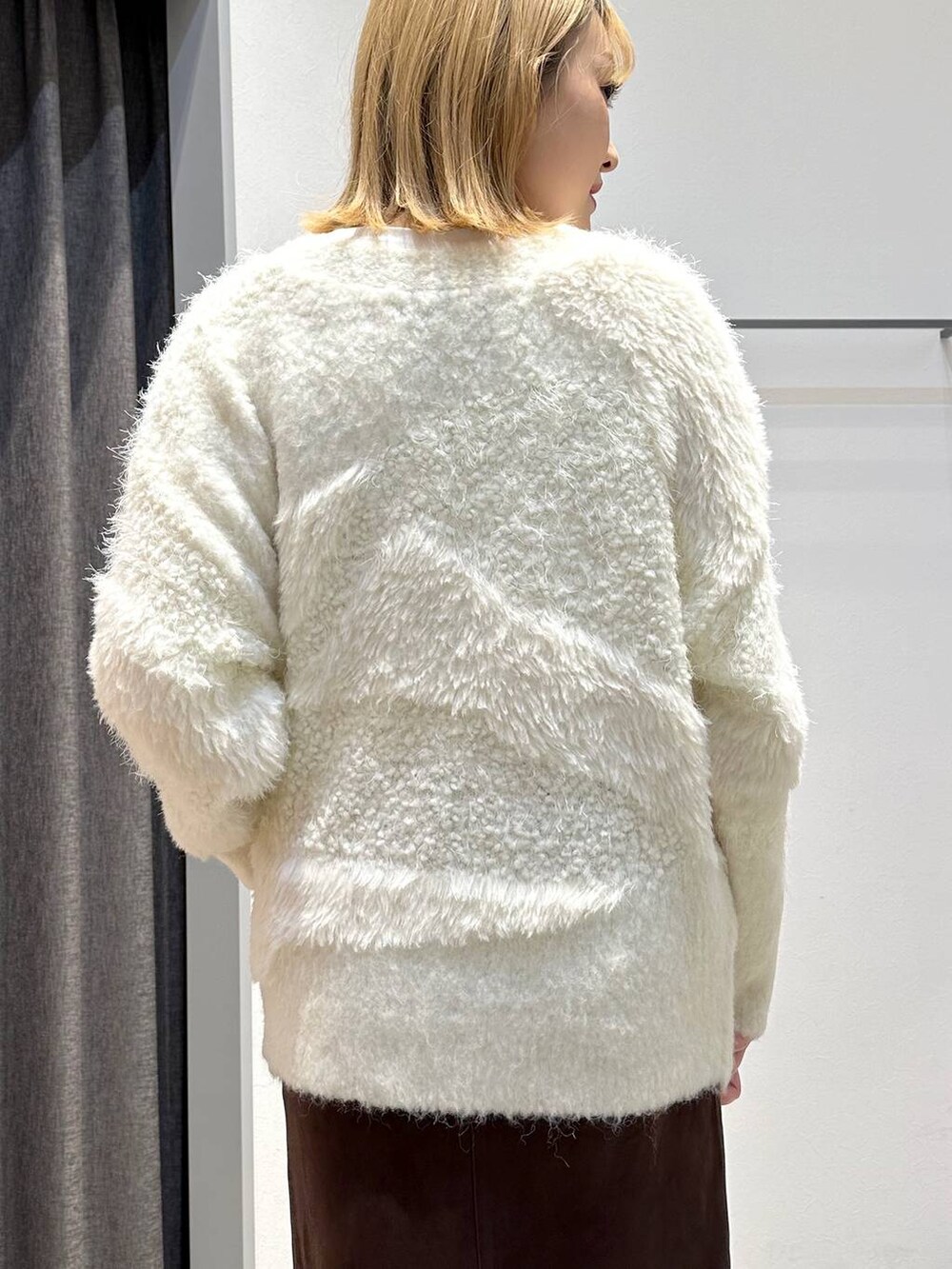 ホワイト系のTシャツ/カットソー、ブラウン系のスカート、ブラック系のトートバッグを着用したレディースの秋コーディネートの7枚目の写真