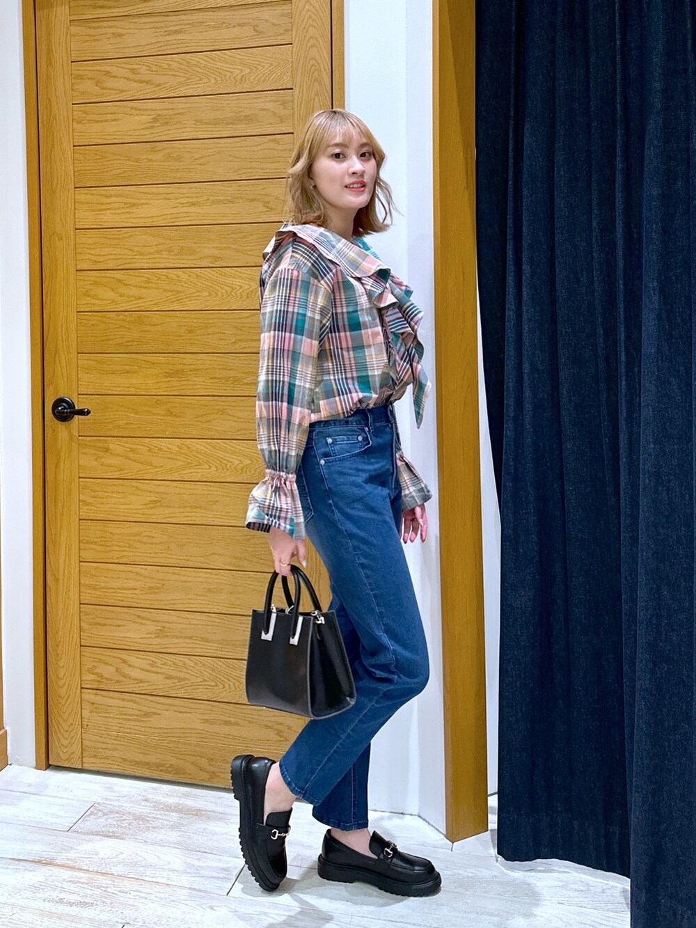 ブラック系のショルダーバッグ、ブルー系のデニムパンツ、ピンク系のシャツ/ブラウスを着用したレディースの冬コーディネートの2枚目の写真