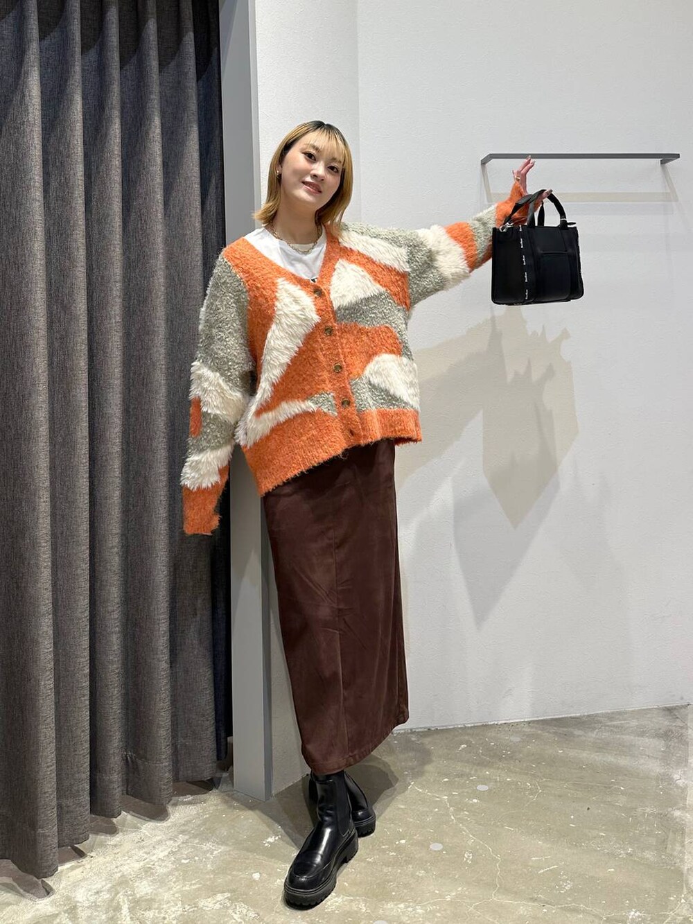 ホワイト系のTシャツ/カットソー、ブラウン系のスカート、ブラック系のトートバッグを着用したレディースの秋コーディネートの9枚目の写真