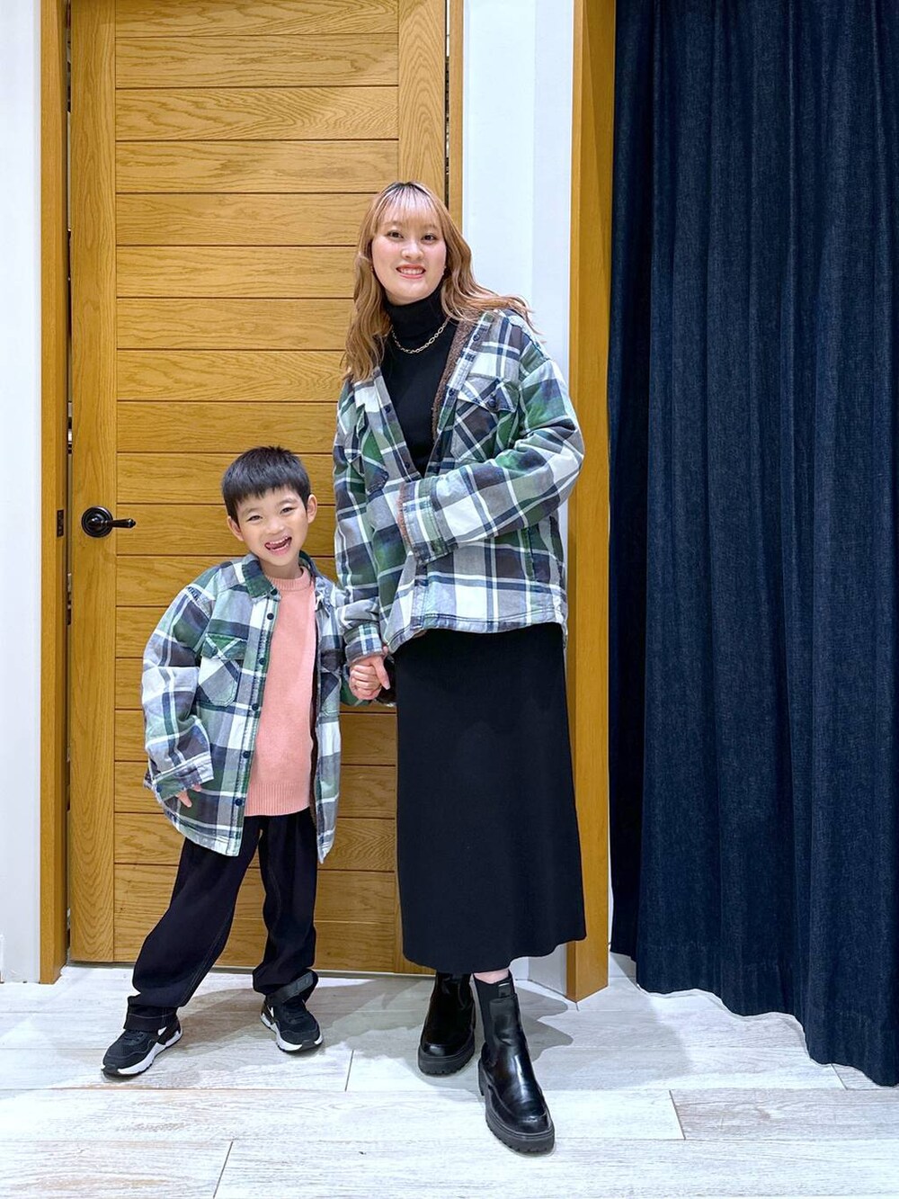 ホワイト系のシャツ/ブラウス、ブラック系のニット/セーター、ブラック系のブーツを着用したレディースの冬コーディネートの4枚目の写真