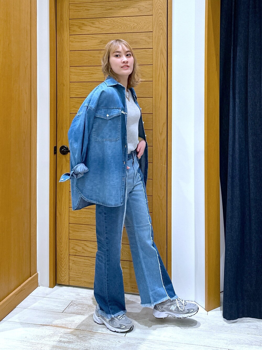 ブルー系のデニムパンツ、グレー系のニット/セーター、ブルー系のシャツ/ブラウスを着用したレディースの冬コーディネートの2枚目の写真