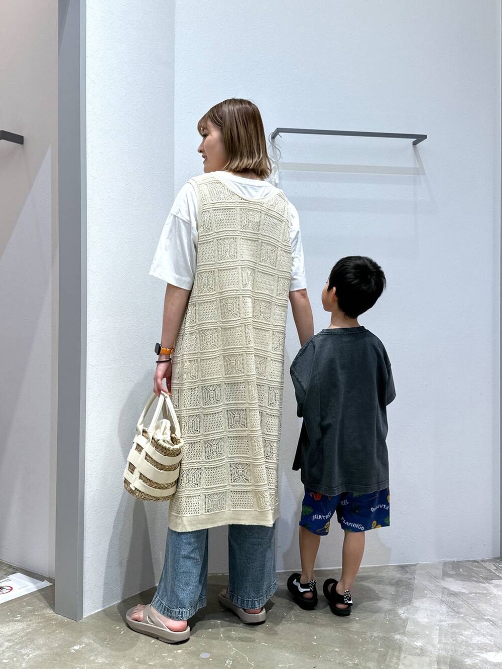ベージュ系のサンダル、ホワイト系のかごバッグ、ブルー系のデニムパンツを着用したレディースの夏コーディネートの2枚目の写真