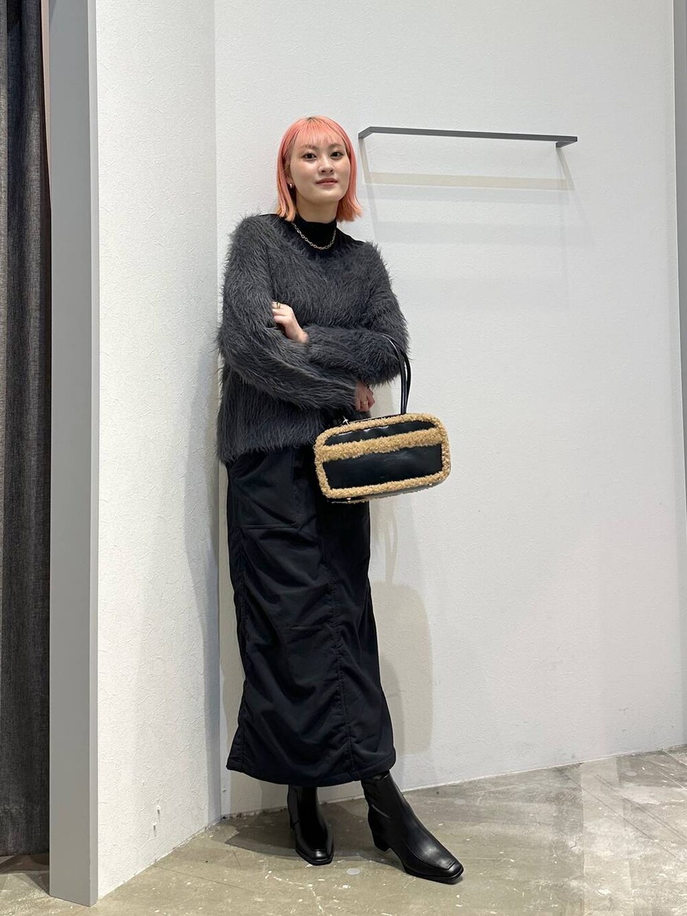 ブラック系のスカート、ブラック系のブーツ、ブラック系のTシャツ/カットソーを着用したレディースの秋コーディネートの8枚目の写真