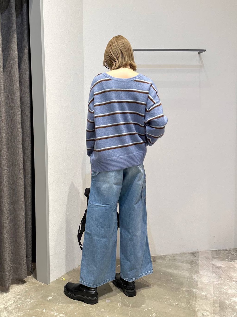 ブルー系のニット/セーター、ブルー系のデニムパンツ、ブラック系のバックパック/リュックを着用したレディースの冬コーディネートの3枚目の写真