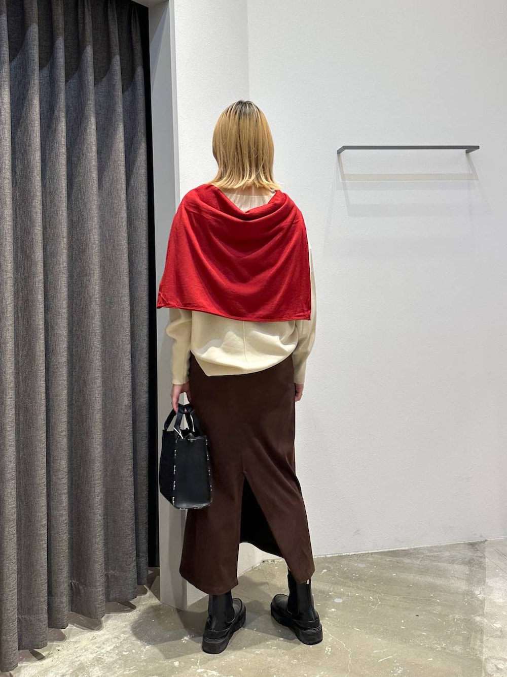 ブラウン系のスカート、ホワイト系のニット/セーター、ブラック系のトートバッグを着用したレディースの秋コーディネートの3枚目の写真