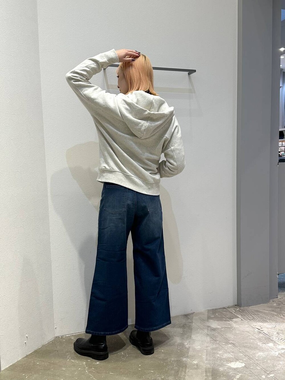 ブルー系のデニムパンツ、ホワイト系のパーカー、ブラック系のニット/セーターを着用したレディースの冬コーディネートの3枚目の写真