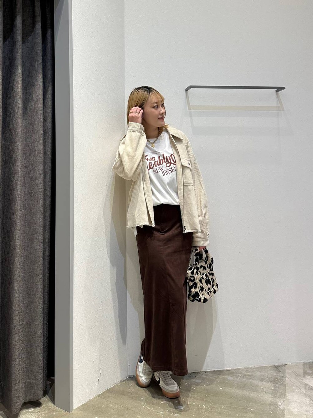 ブラウン系のスカート、ホワイト系のTシャツ/カットソー、ホワイト系のブルゾンを着用したレディースの秋コーディネートの9枚目の写真