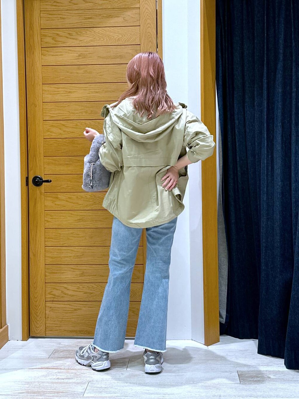 ブラウン系のマウンテンパーカー、ブルー系のデニムパンツ、ホワイト系のTシャツ/カットソーを着用したレディースの秋コーディネートの3枚目の写真