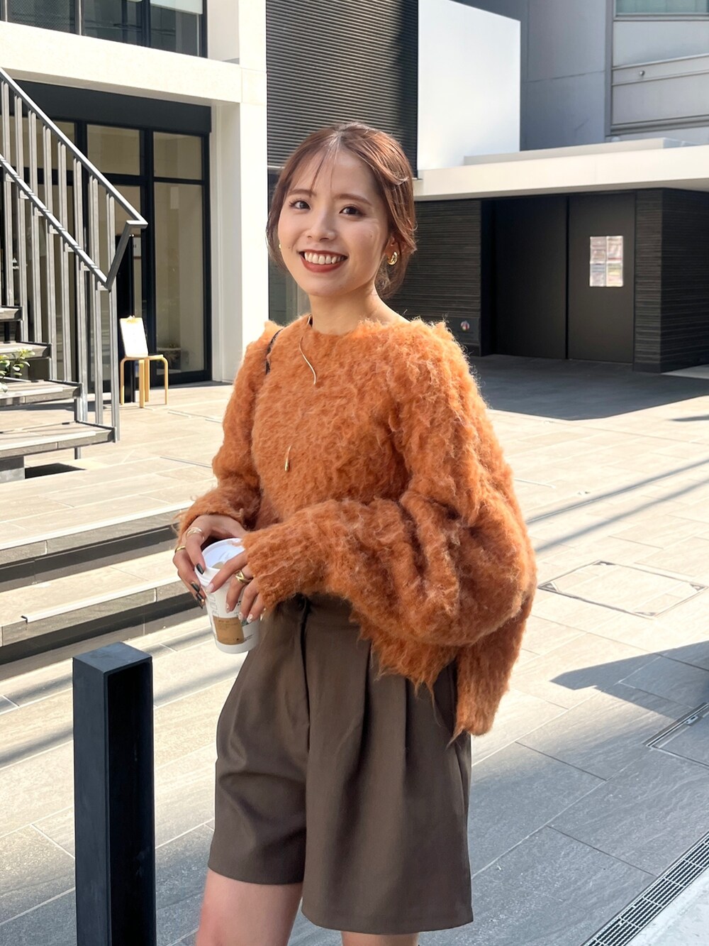 ブラック系のブーツ、オレンジ系のニット/セーター、グリーン系のその他パンツを着用したレディースの秋コーディネートの4枚目の写真