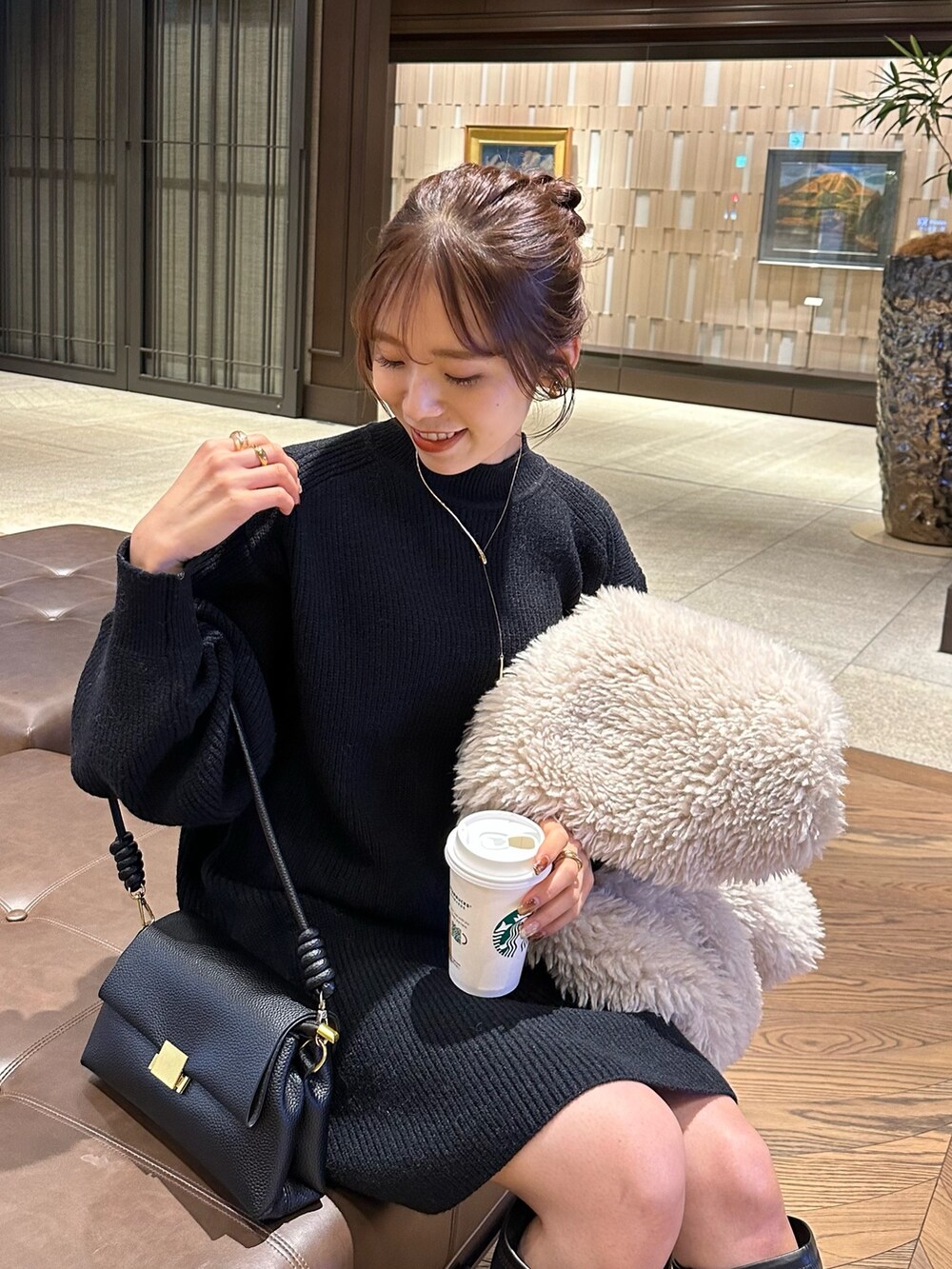 ベージュ系のノーカラーコート、ブラック系のワンピース、ブラック系のブーツを着用したレディースの秋コーディネートの4枚目の写真