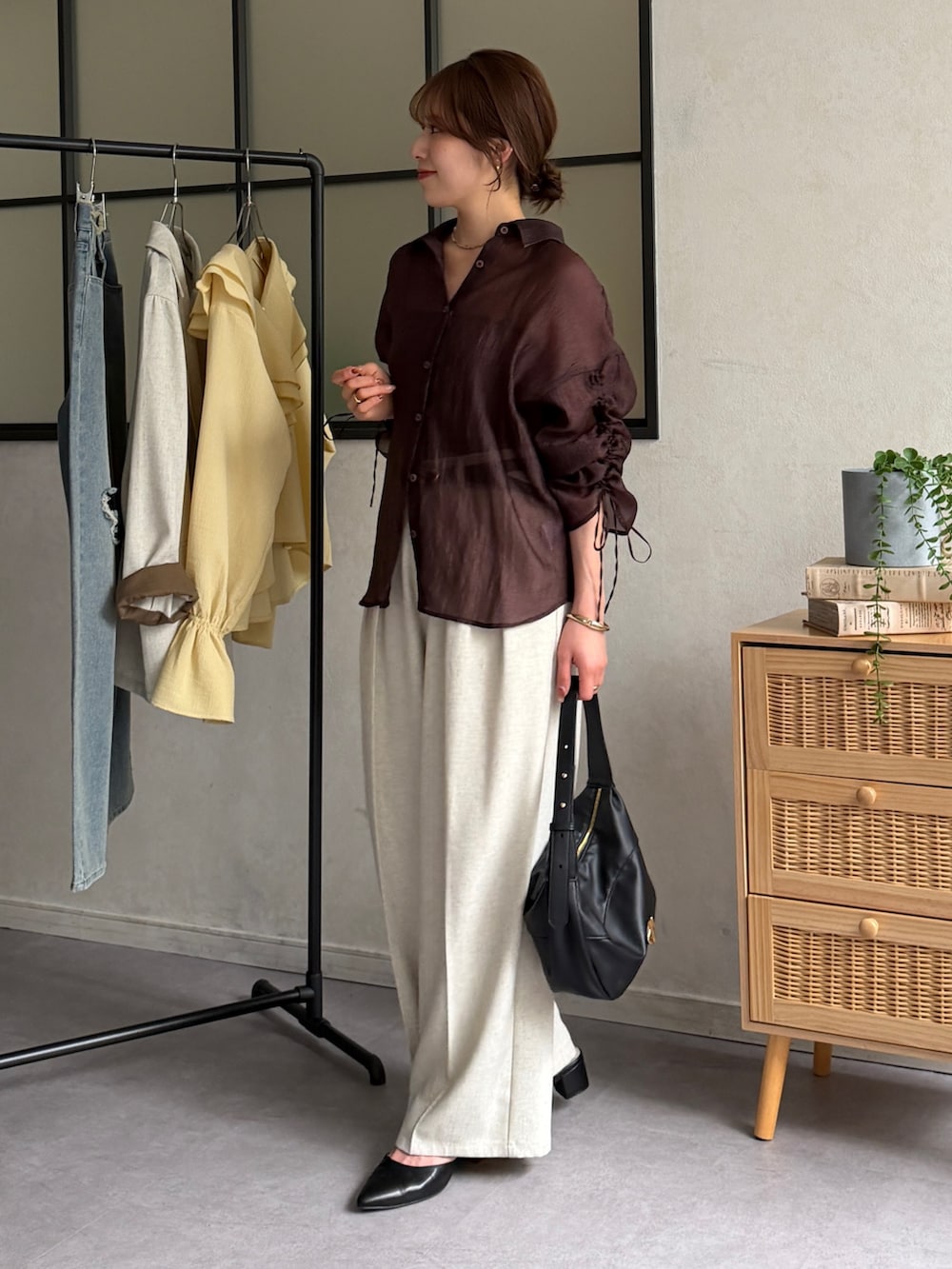 ブラウン系のシャツ/ブラウス、ブラック系のパンプス、ホワイト系のスラックスを着用したレディースの春コーディネートの2枚目の写真