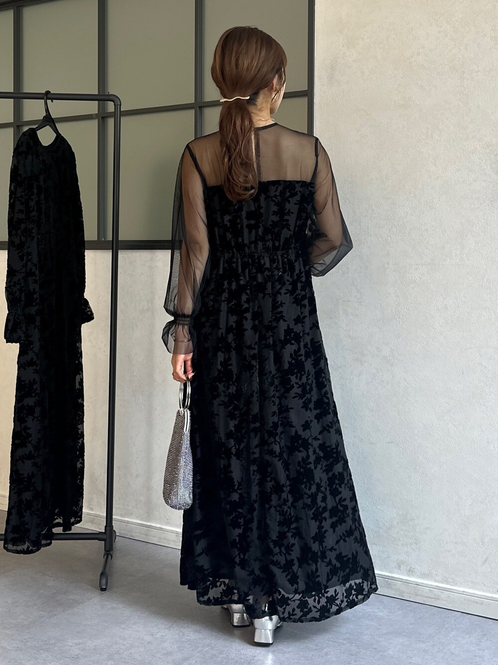 ブラック系のワンピース、シルバー系のトートバッグ、シルバー系のパンプスを着用したレディースの冬コーディネートの4枚目の写真