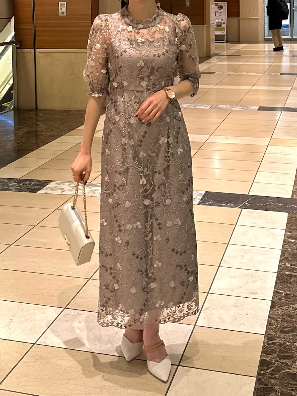 ピンク系のドレス、ベージュ系のハンドバッグを着用したレディースの冬コーディネートの5枚目の写真