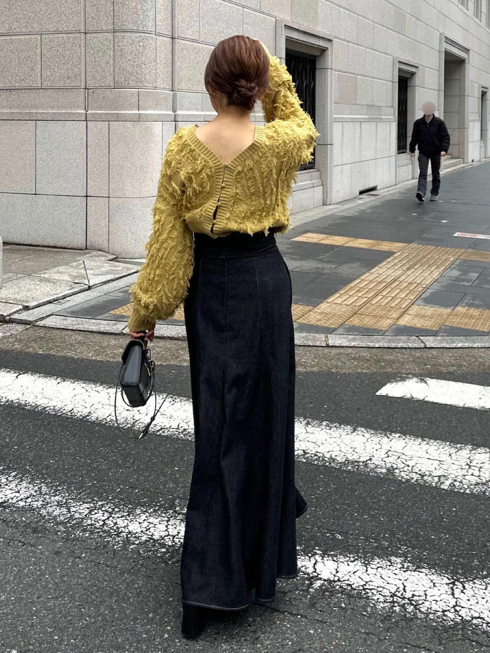 イエロー系のカーディガン/ボレロ、ベージュ系のステンカラーコートを着用したレディースの冬コーディネートの2枚目の写真