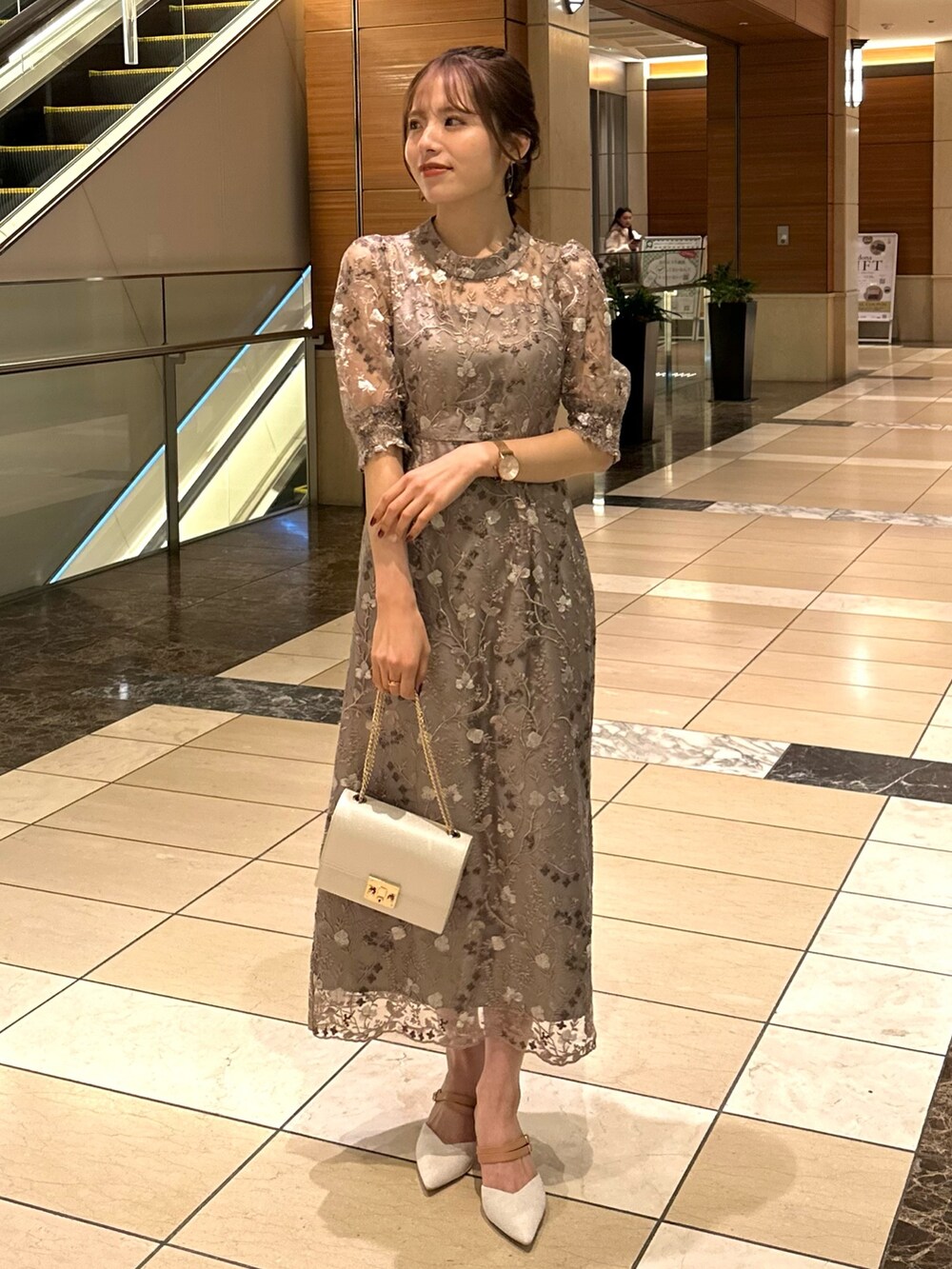 ピンク系のドレス、ベージュ系のハンドバッグを着用したレディースの冬コーディネートの4枚目の写真