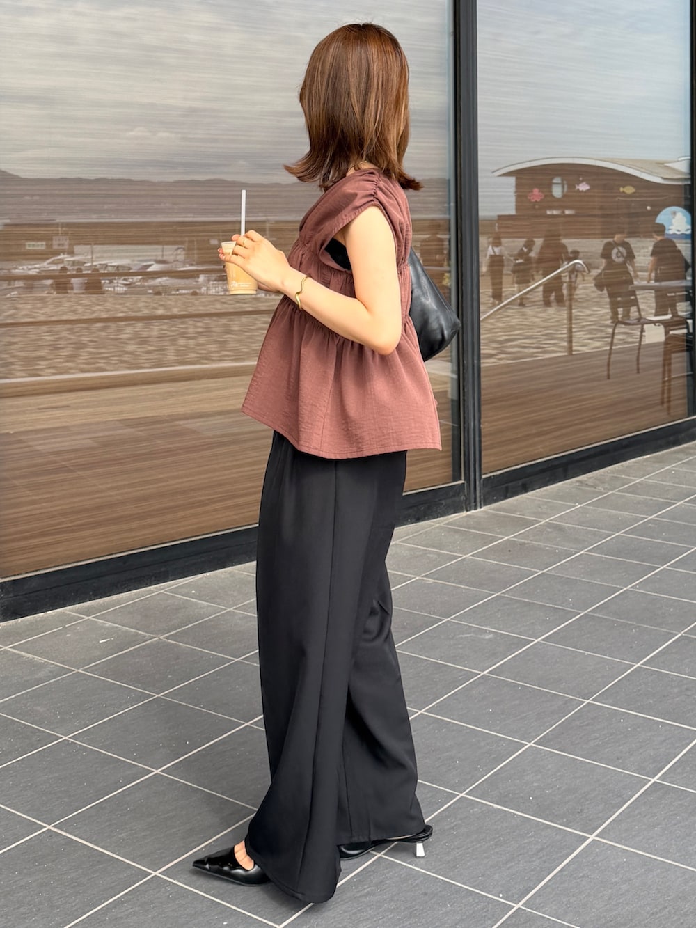 ブラウン系のつなぎ/オールインワン、ブラック系のスラックスを着用したレディースの夏コーディネートの2枚目の写真