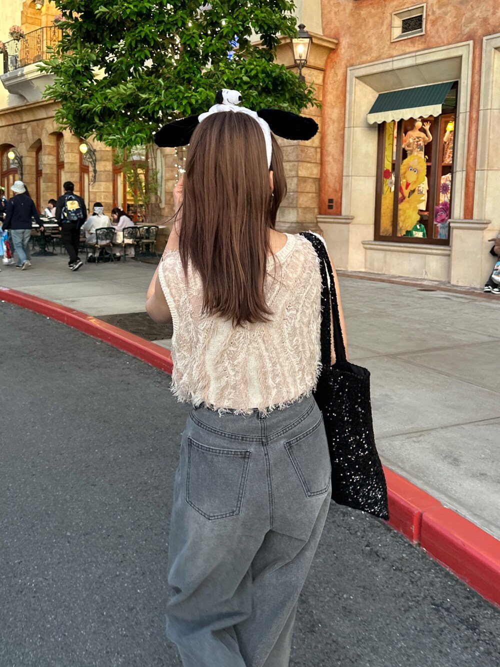 ブラック系のデニムパンツ、ホワイト系のニット/セーターを着用したレディースの春コーディネートの4枚目の写真