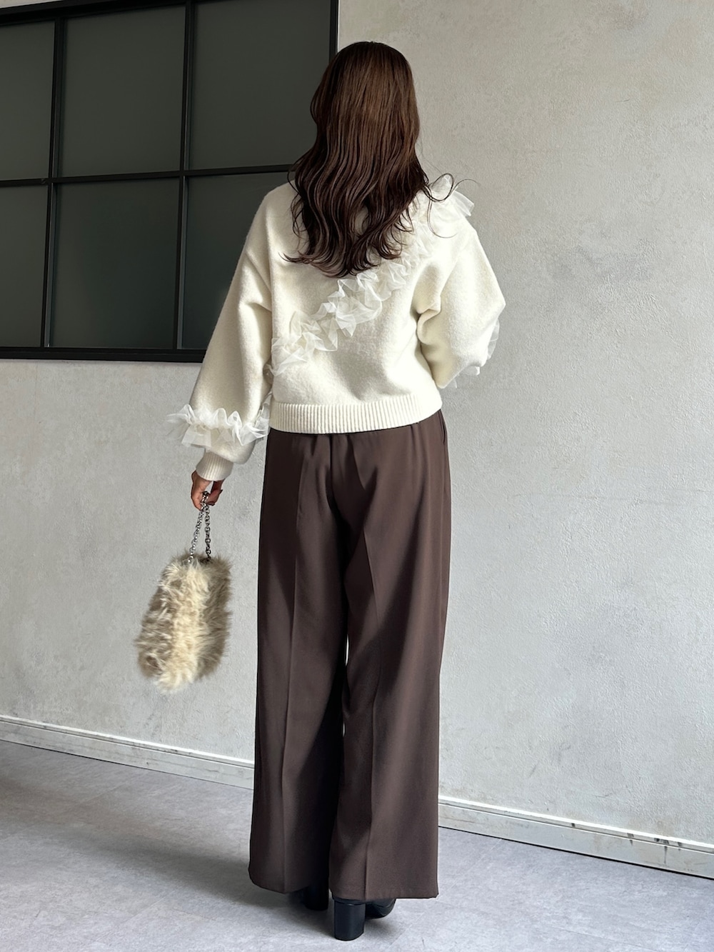 ブラウン系のその他パンツ、ブラック系のブーツ、ホワイト系のニット/セーターを着用したレディースの冬コーディネートの2枚目の写真