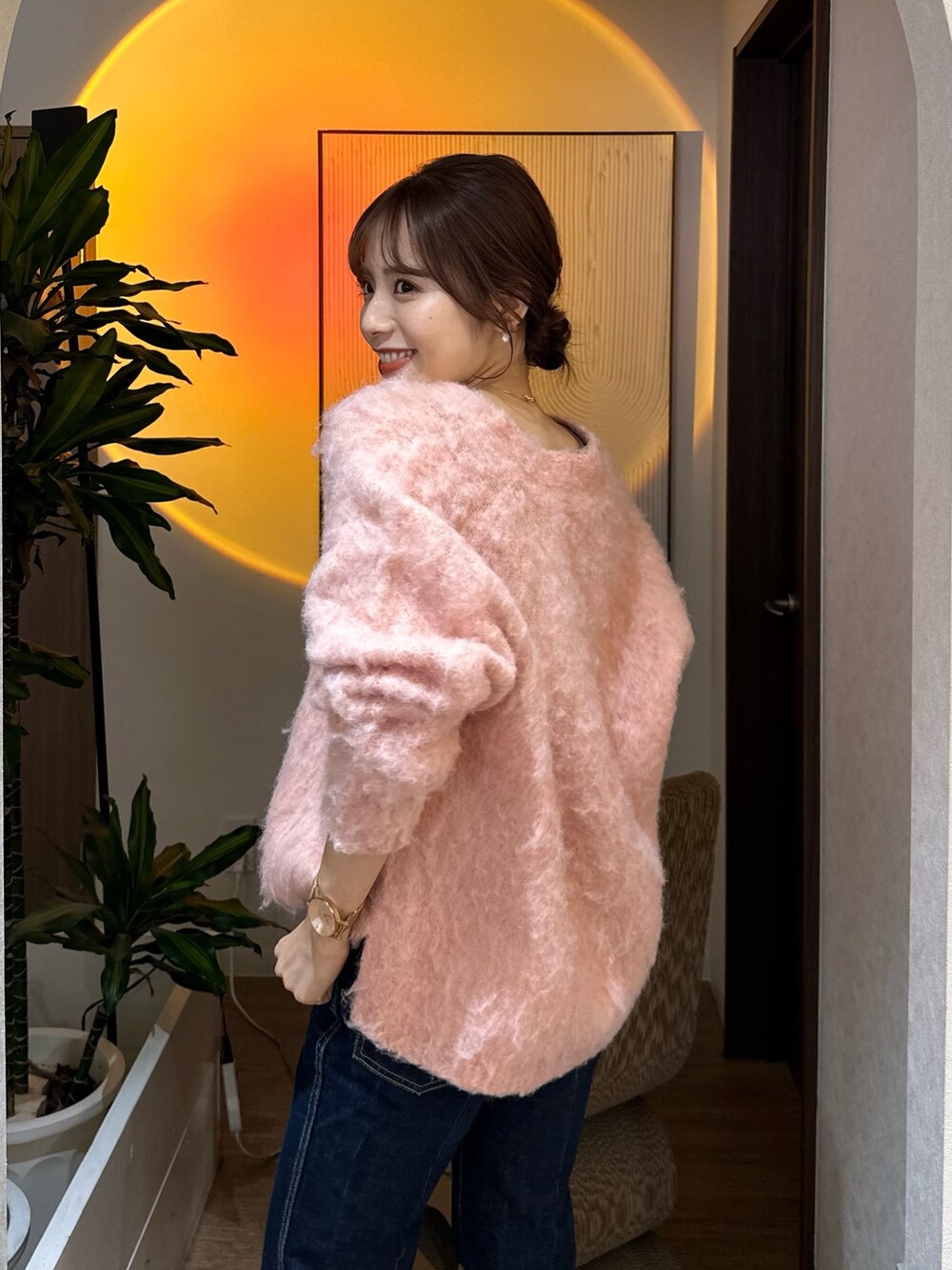 ブラック系のブーツ、ブルー系のデニムパンツを着用したレディースの秋コーディネートの2枚目の写真