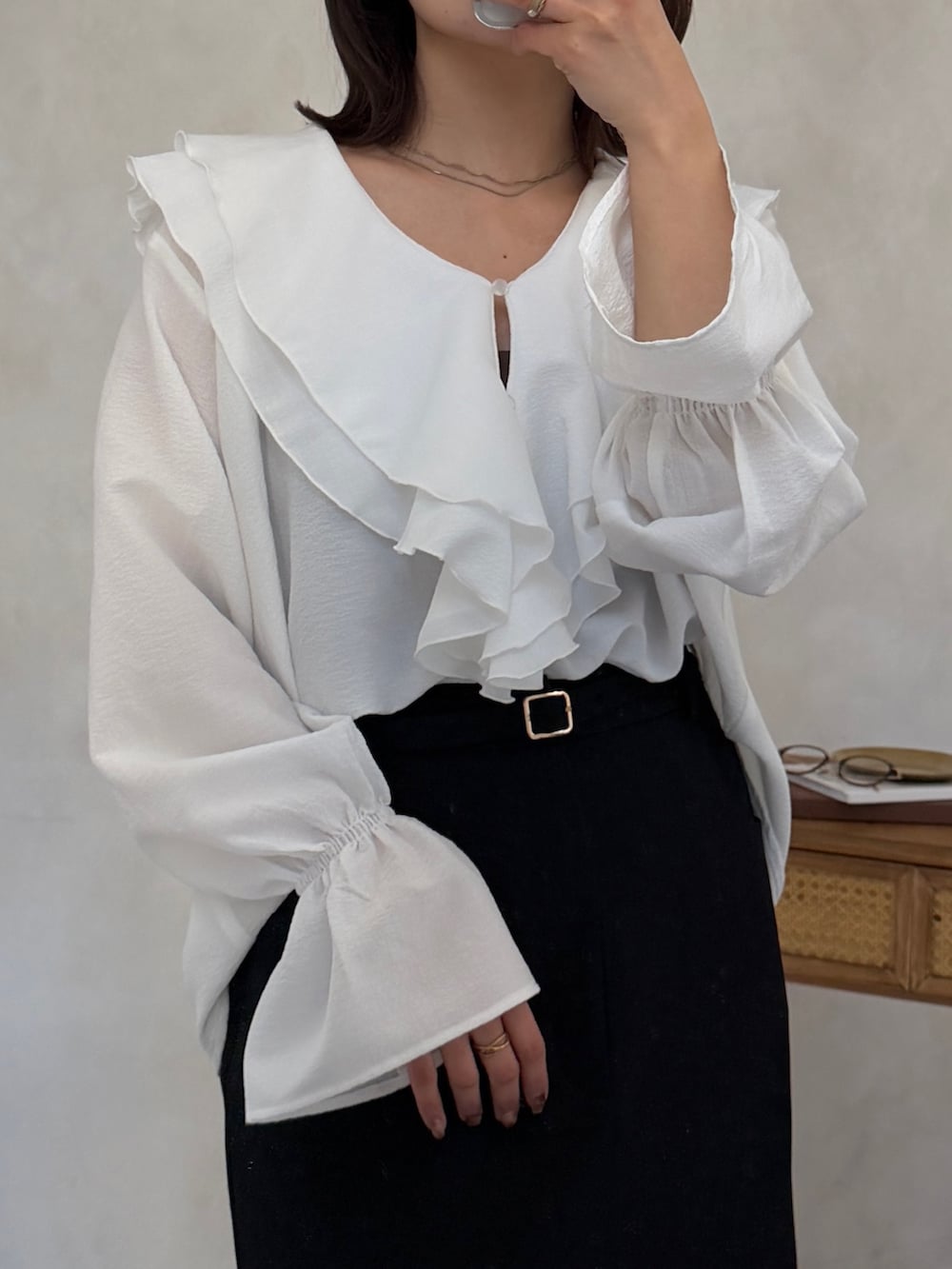 ブラック系のスカート、ブラウン系のショルダーバッグ、ホワイト系のシャツ/ブラウスを着用したレディースの冬コーディネートの2枚目の写真