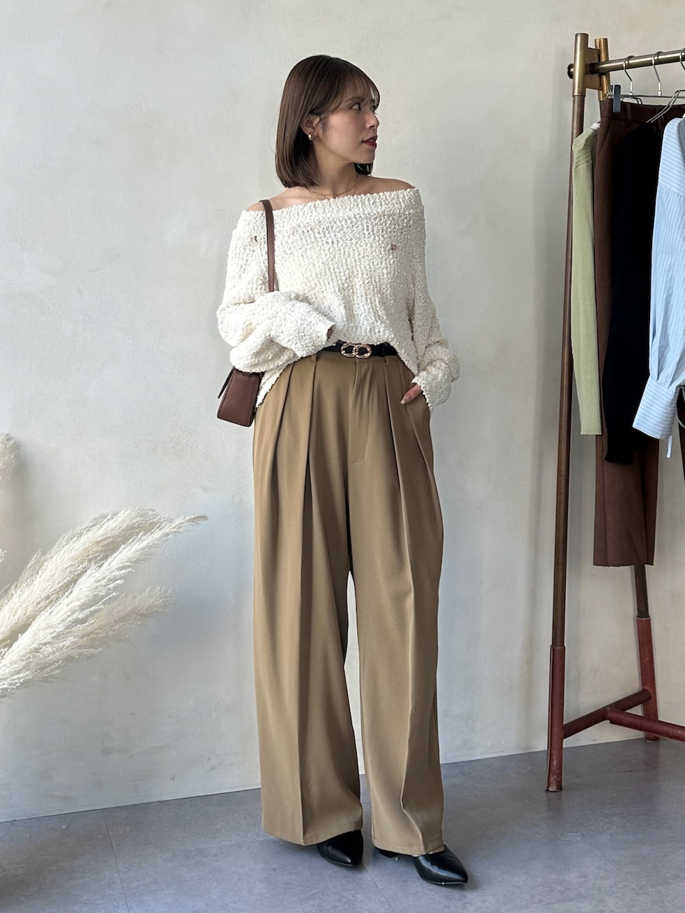 イエロー系のスラックス、ブラック系のパンプス、ホワイト系のニット/セーターを着用したレディースの冬コーディネートの4枚目の写真