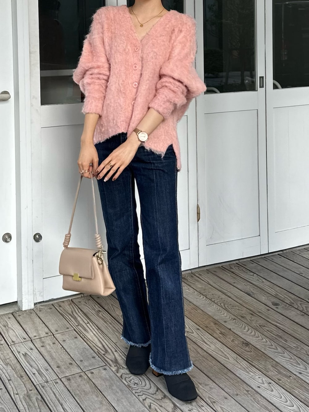 ブラック系のブーツ、ブルー系のデニムパンツを着用したレディースの秋コーディネートの5枚目の写真