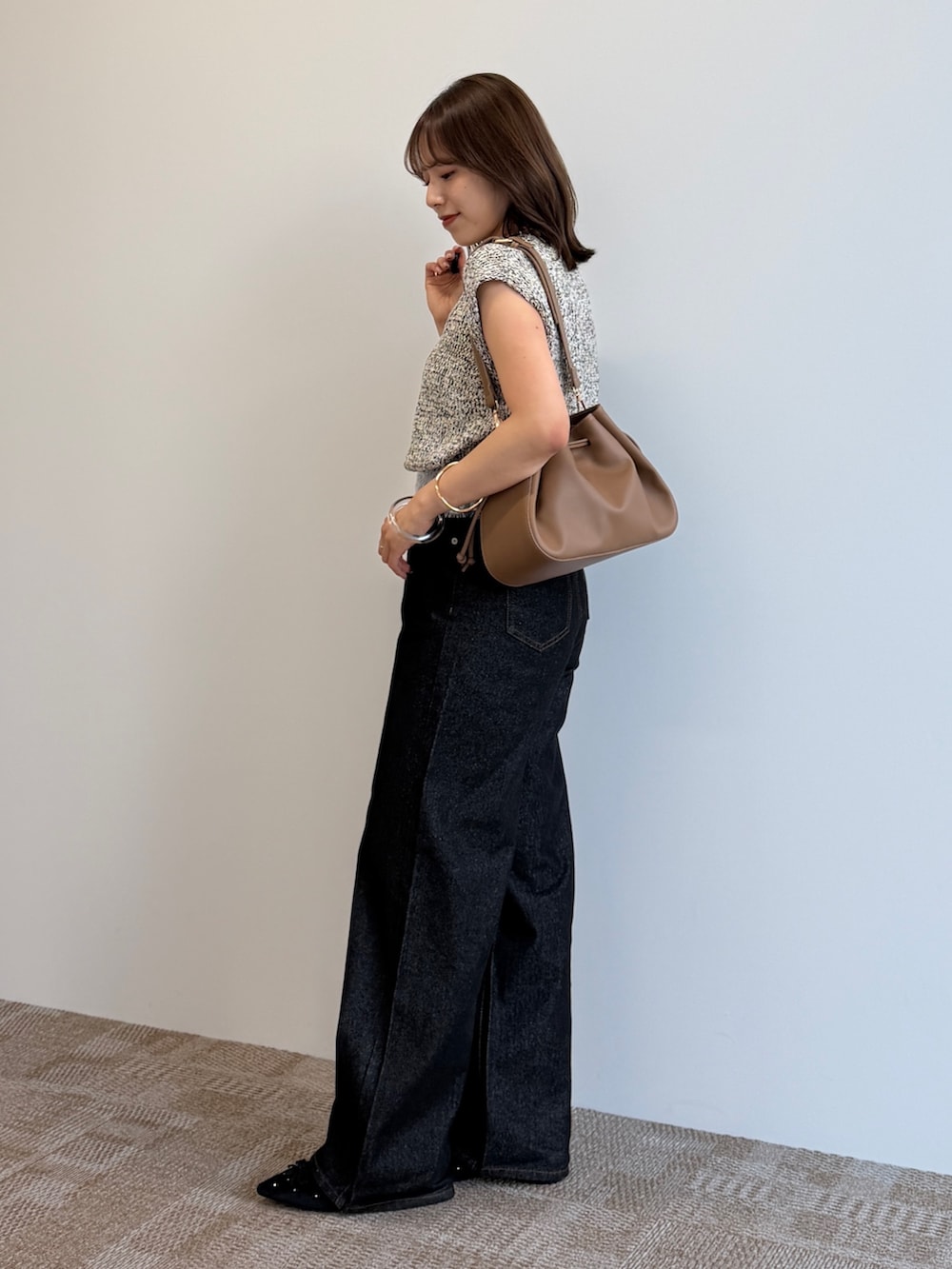 ブラック系のデニムパンツ、ブラック系のパンプス、ベージュ系のニット/セーターを着用したレディースの夏コーディネートの3枚目の写真