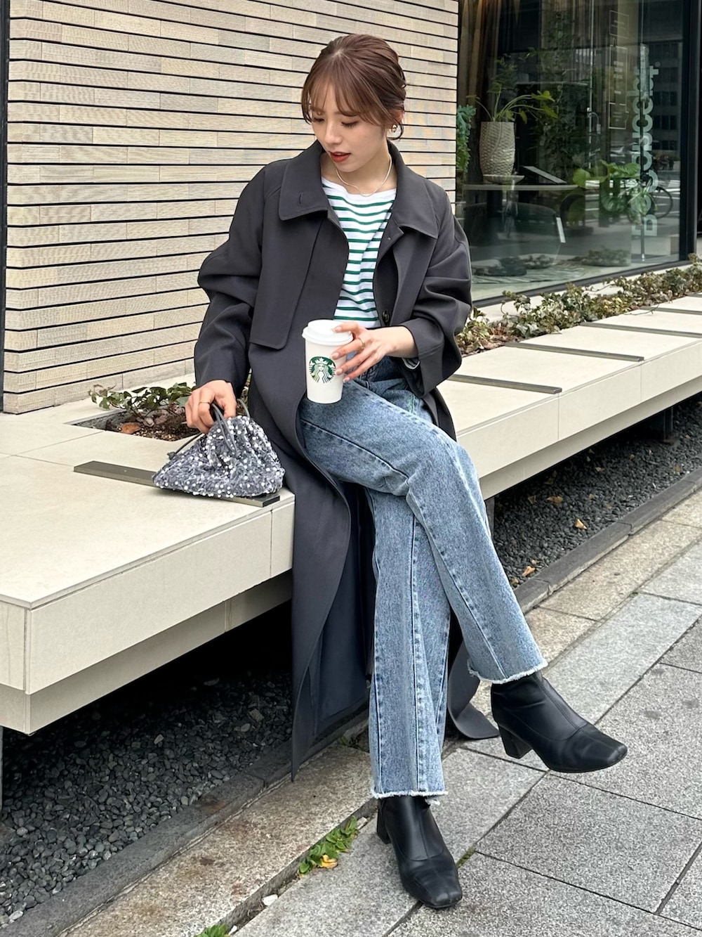 ブルー系のデニムパンツ、グレー系のトートバッグ、グレー系のステンカラーコートを着用したレディースの冬コーディネートの2枚目の写真