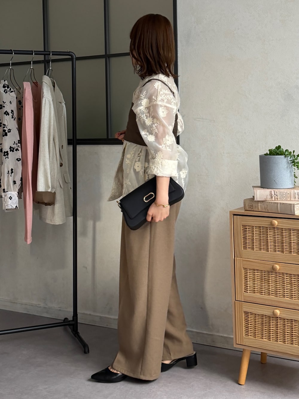 ブラウン系のスラックス、ブラック系のパンプス、ホワイト系のテーラードジャケットを着用したレディースの春コーディネートの3枚目の写真