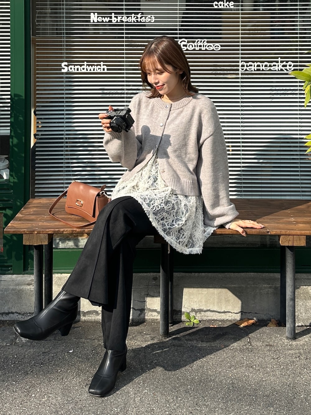 グレー系のカーディガン/ボレロ、ホワイト系のチュニック、ブラウン系のショルダーバッグを着用したレディースの冬コーディネートの2枚目の写真