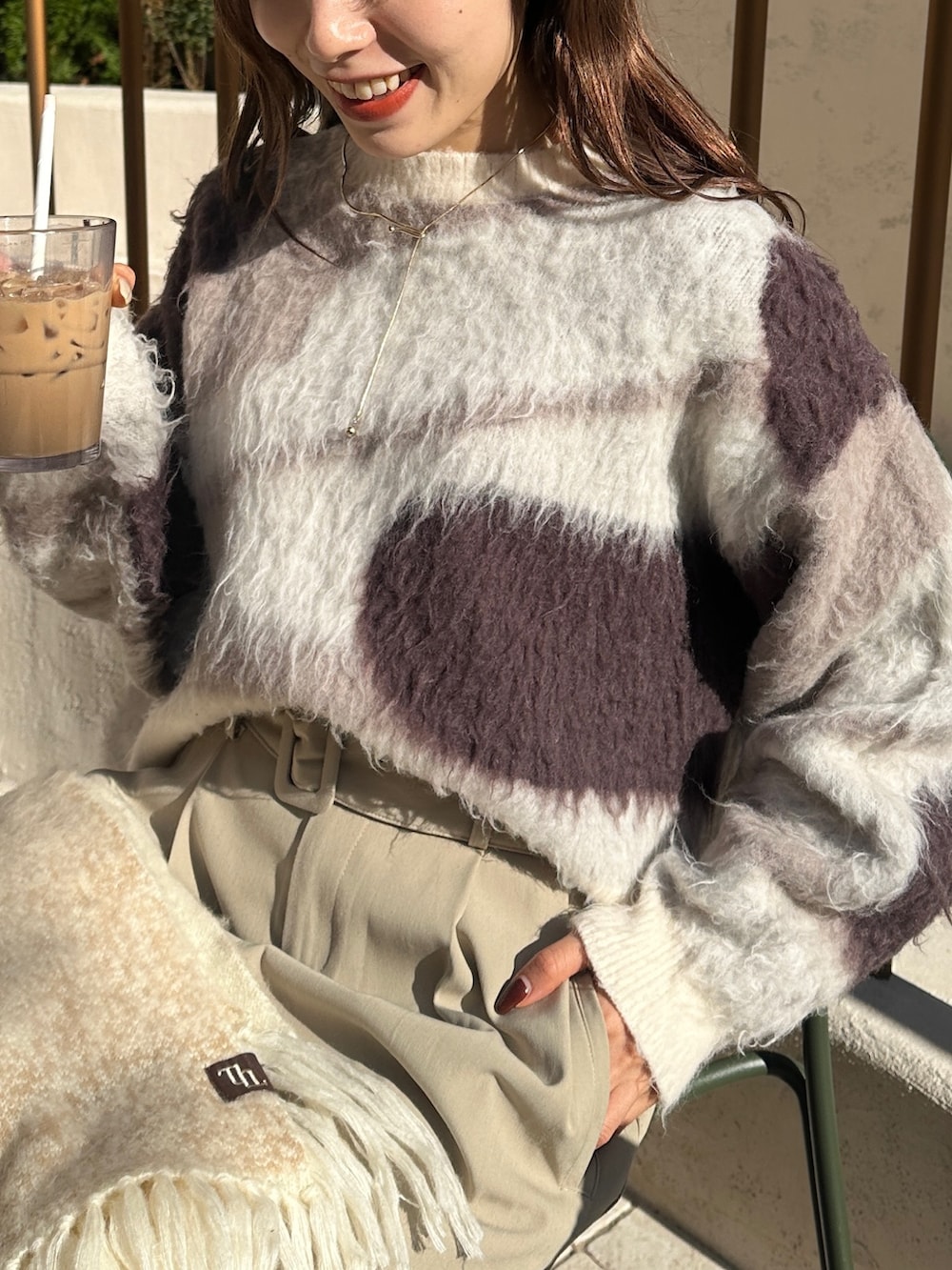 ブラウン系のその他アウター、ベージュ系のスラックス、ホワイト系のニット/セーターを着用したレディースの冬コーディネートの6枚目の写真