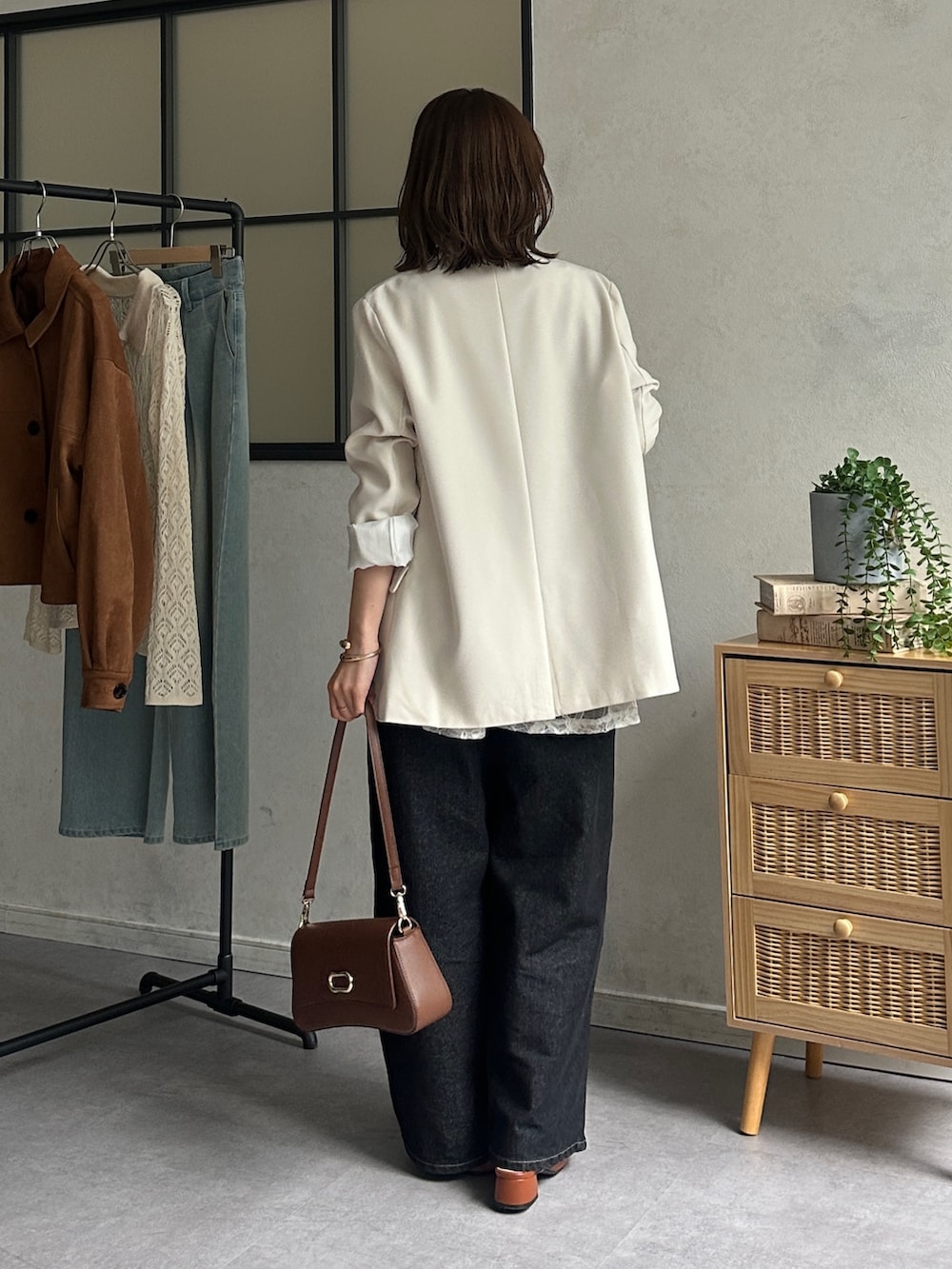 ホワイト系のテーラードジャケット、ブラック系のデニムパンツ、オレンジ系のパンプスを着用したレディースの冬コーディネートの3枚目の写真