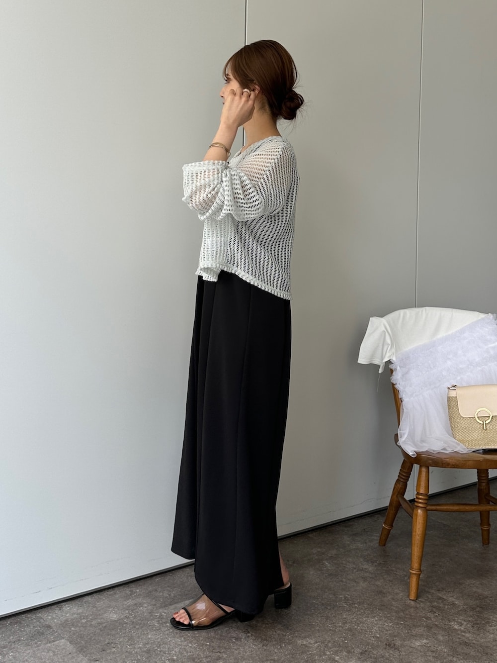 グリーン系のニット/セーター、ブラック系のサンダル、グレー系のトートバッグを着用したレディースの春コーディネートの2枚目の写真