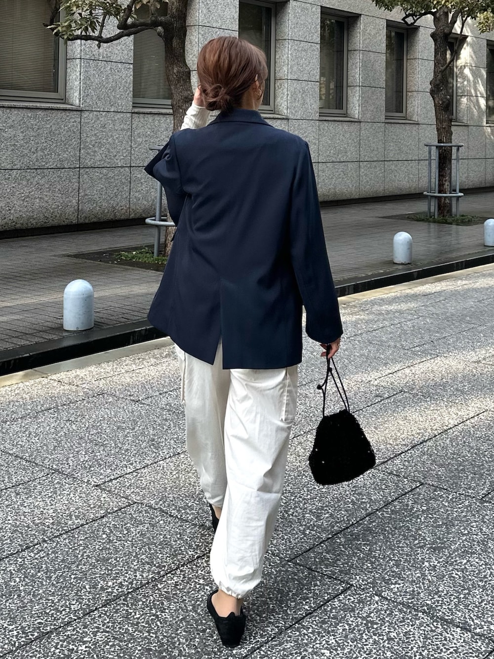 ブルー系のテーラードジャケット、ブラック系のトートバッグ、ブラック系のパンプスを着用したレディースの冬コーディネートの5枚目の写真