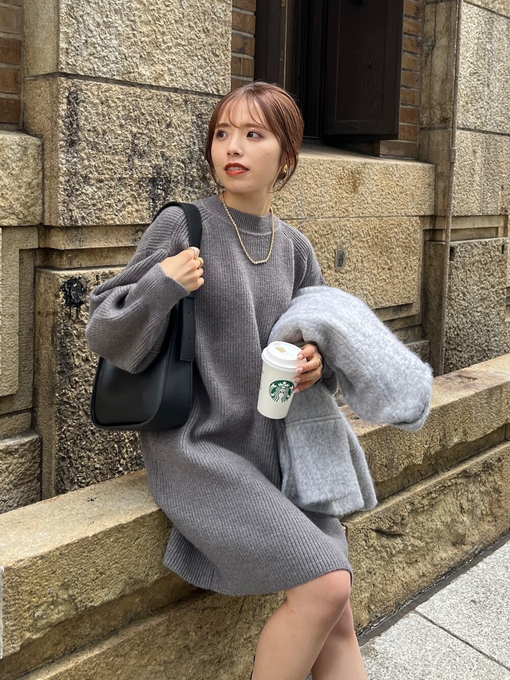 グレー系のピーコート、グレー系のワンピース、ブラック系のブーツを着用したレディースの秋コーディネートの3枚目の写真
