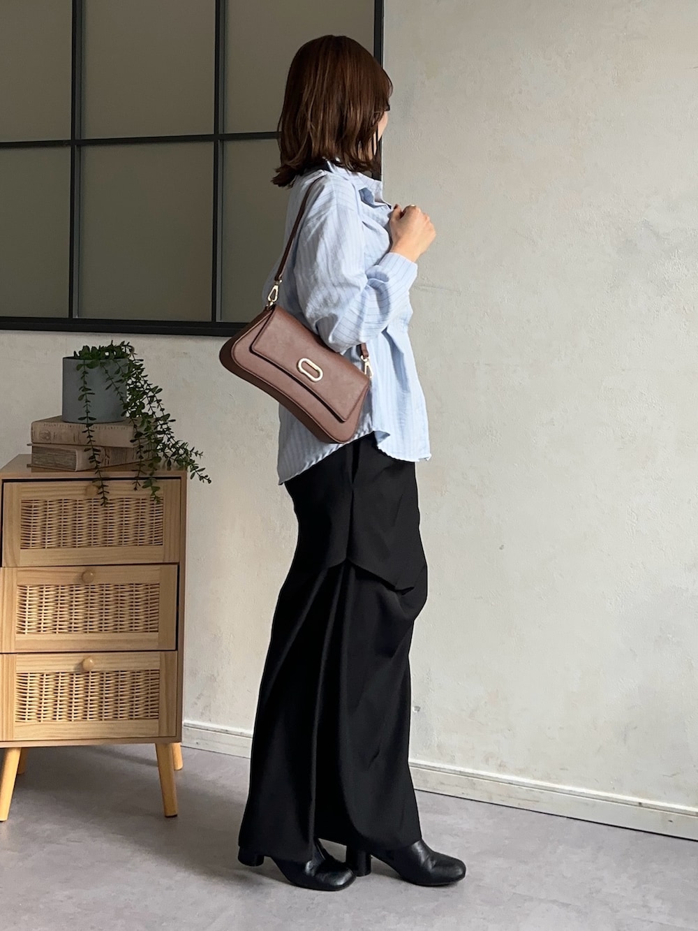 ブラック系のスカート、ブルー系のシャツ/ブラウス、ブラウン系のショルダーバッグを着用したレディースの冬コーディネートの4枚目の写真