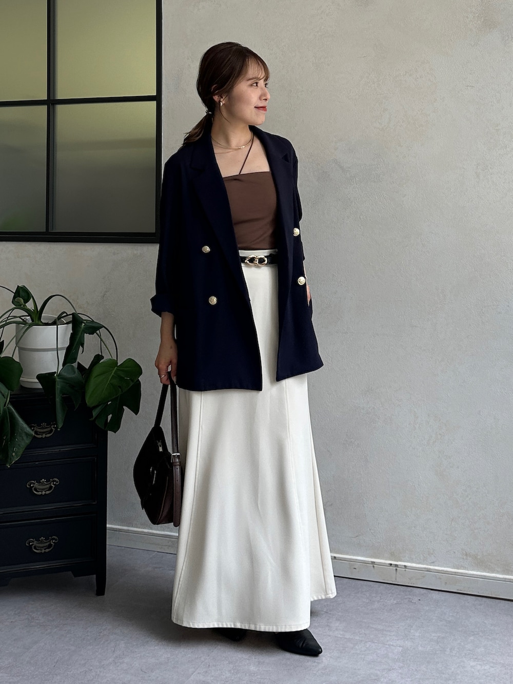 ホワイト系のスカート、ブラック系のパンプス、ブルー系のテーラードジャケットを着用したレディースの夏コーディネートの4枚目の写真