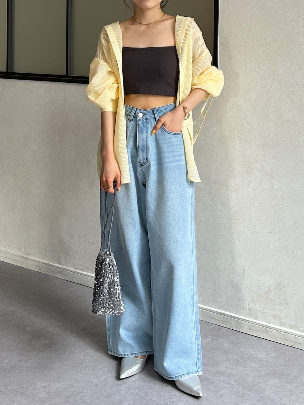 ブルー系のデニムパンツ、シルバー系のパンプス、イエロー系のシャツ/ブラウスを着用したレディースの春コーディネートの5枚目の写真
