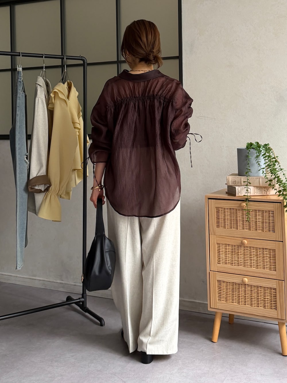 ブラウン系のシャツ/ブラウス、ブラック系のパンプス、ホワイト系のスラックスを着用したレディースの春コーディネートの3枚目の写真