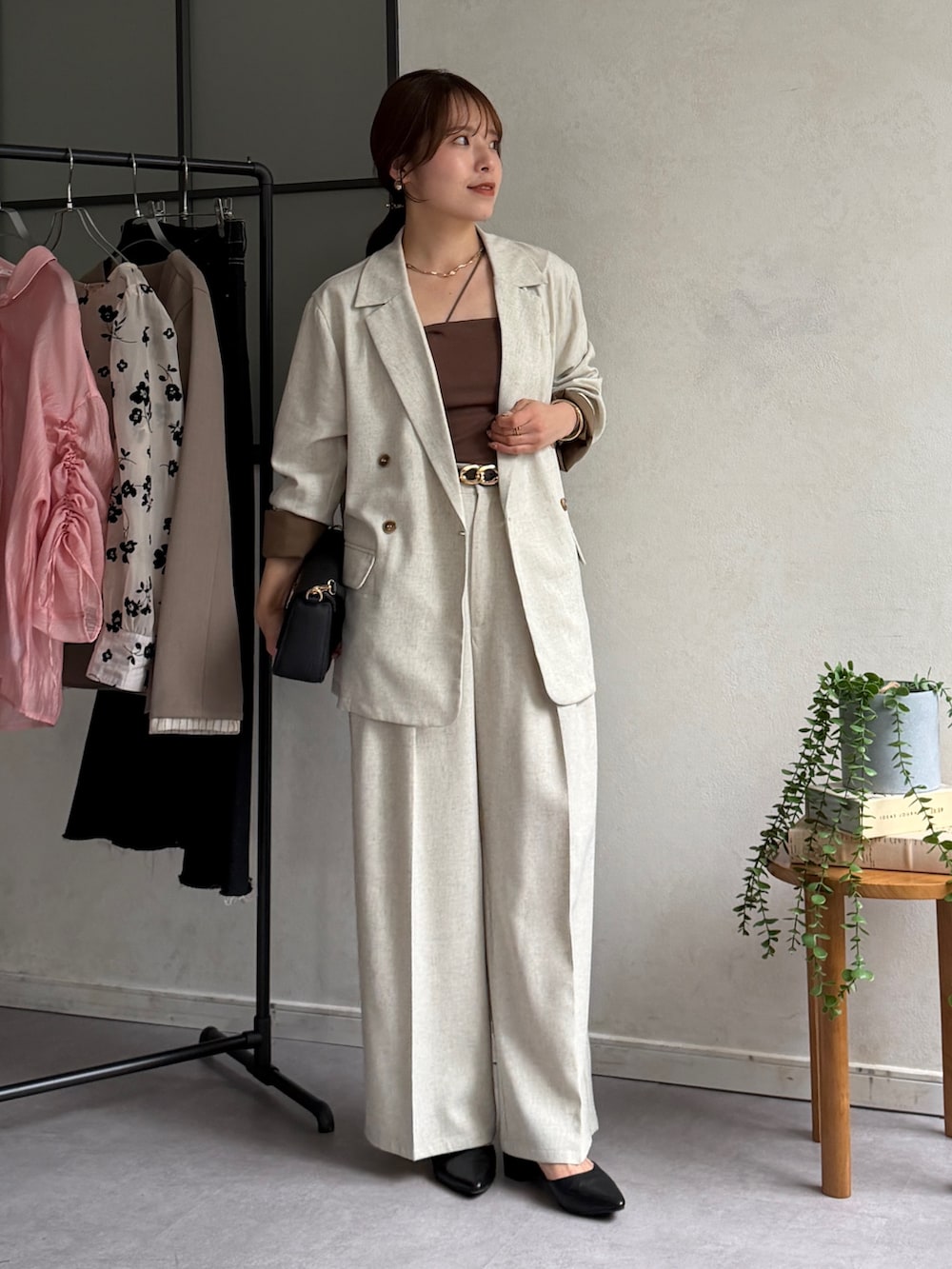 ベージュ系のテーラードジャケット、ホワイト系のスラックス、ブラック系のパンプスを着用したレディースの春コーディネートの4枚目の写真