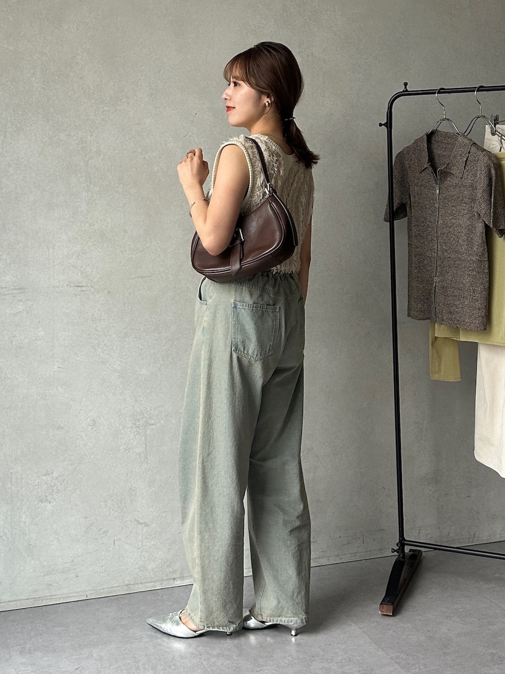 ブルー系のデニムパンツ、ホワイト系のニット/セーター、ブラック系のパンプスを着用したレディースの夏コーディネートの3枚目の写真