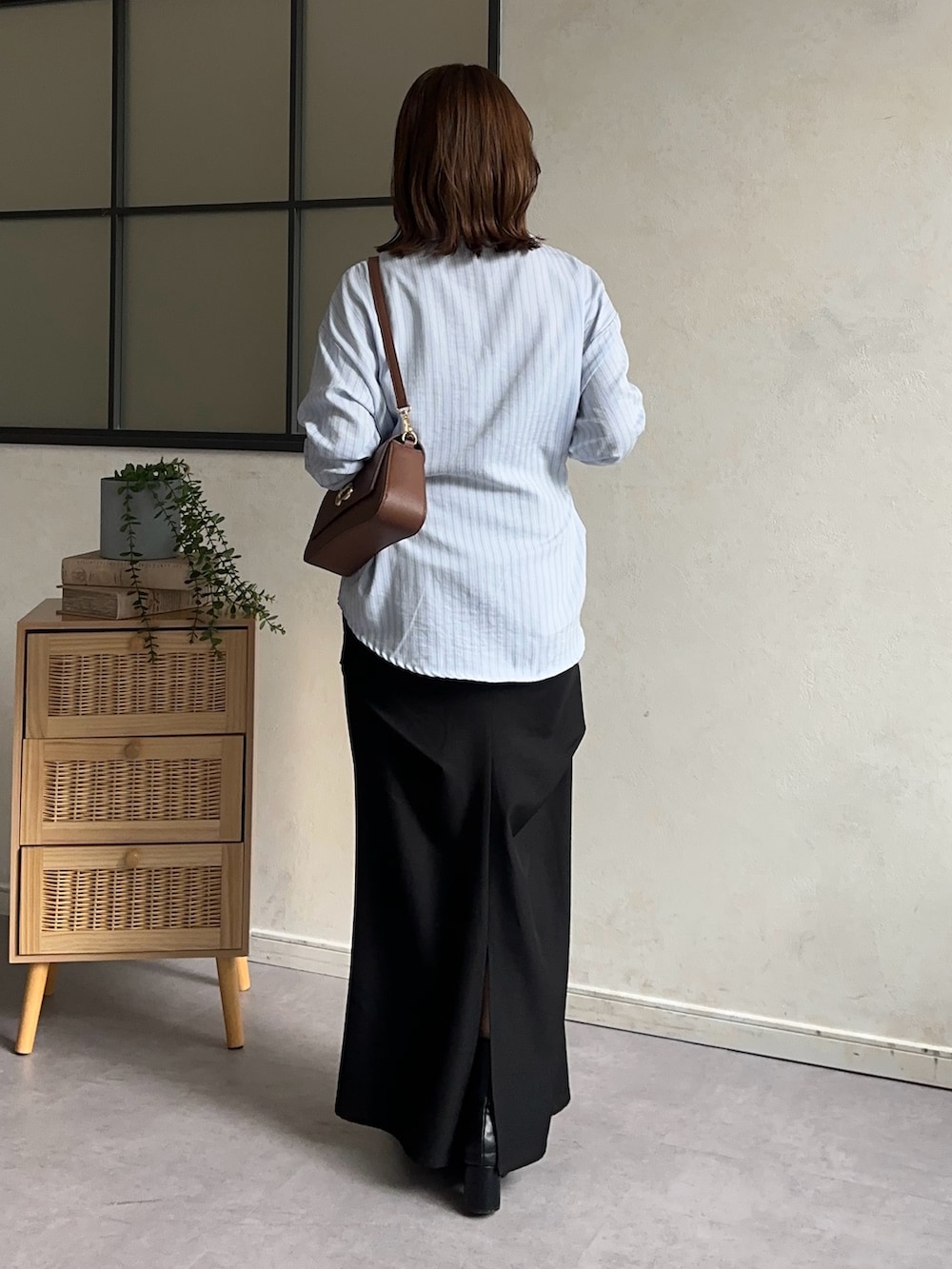 ブラック系のスカート、ブルー系のシャツ/ブラウス、ブラウン系のショルダーバッグを着用したレディースの冬コーディネートの2枚目の写真