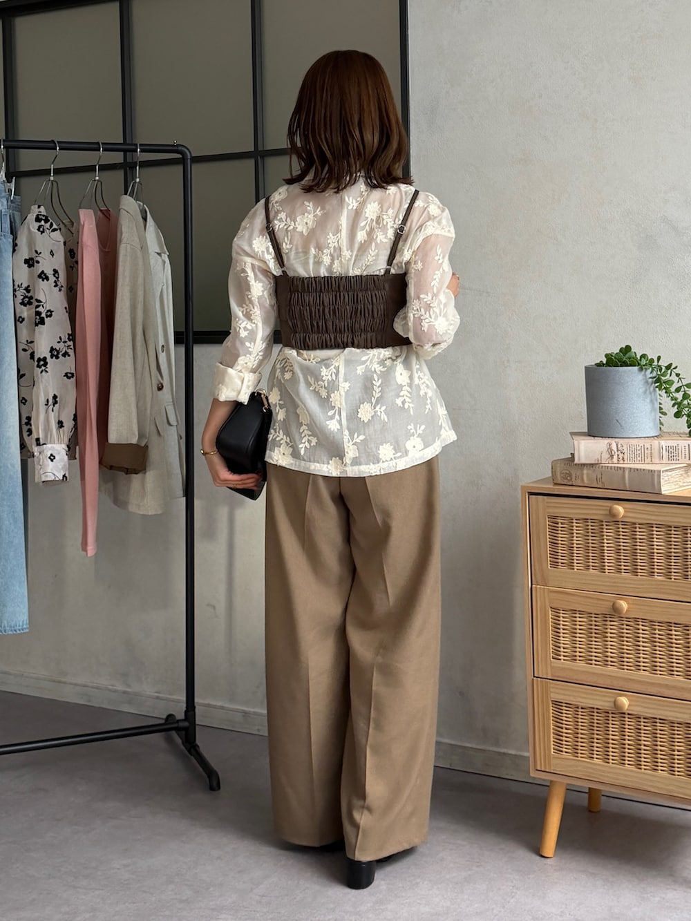 ブラウン系のスラックス、ブラック系のパンプス、ホワイト系のテーラードジャケットを着用したレディースの春コーディネートの4枚目の写真