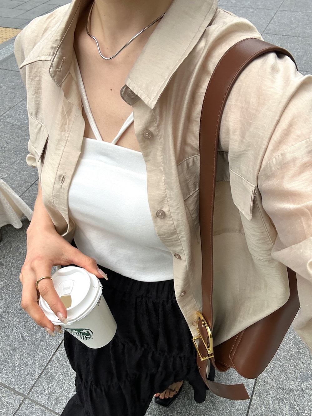 ブラック系のスカート、ベージュ系のシャツ/ブラウス、ブラウン系のショルダーバッグを着用したレディースの春コーディネートの4枚目の写真