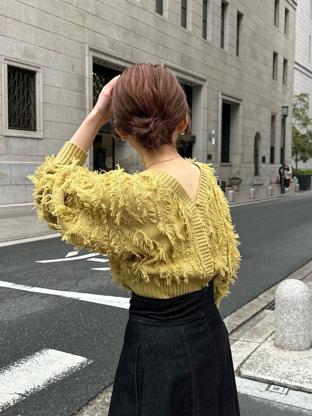 イエロー系のカーディガン/ボレロ、ベージュ系のステンカラーコートを着用したレディースの冬コーディネートの5枚目の写真