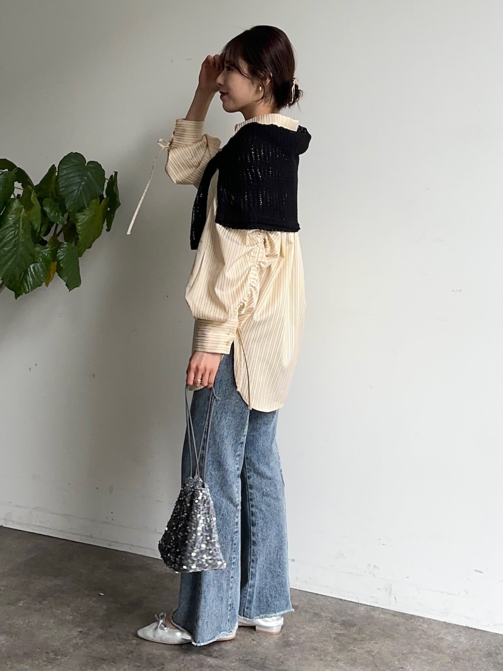 イエロー系のシャツ/ブラウス、ブルー系のデニムパンツ、シルバー系のパンプスを着用したレディースの春コーディネートの2枚目の写真